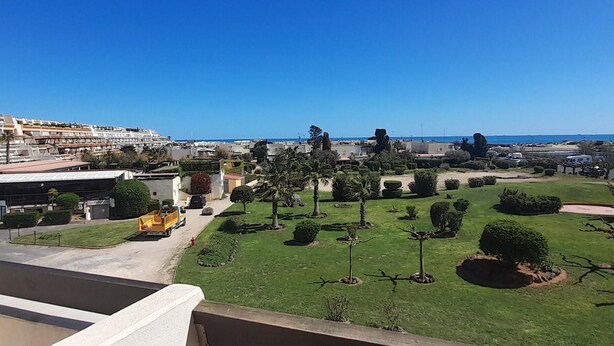 A residential area with a clear view of the sea, a yellow school bus, and well-maintained gardens. - Air-conditioned studio with balcony and parking, Cap d'Agde (Cap d'Agde naturisme)