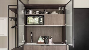 A compact kitchen with a built-in microwave, a sink, and a coffee maker.