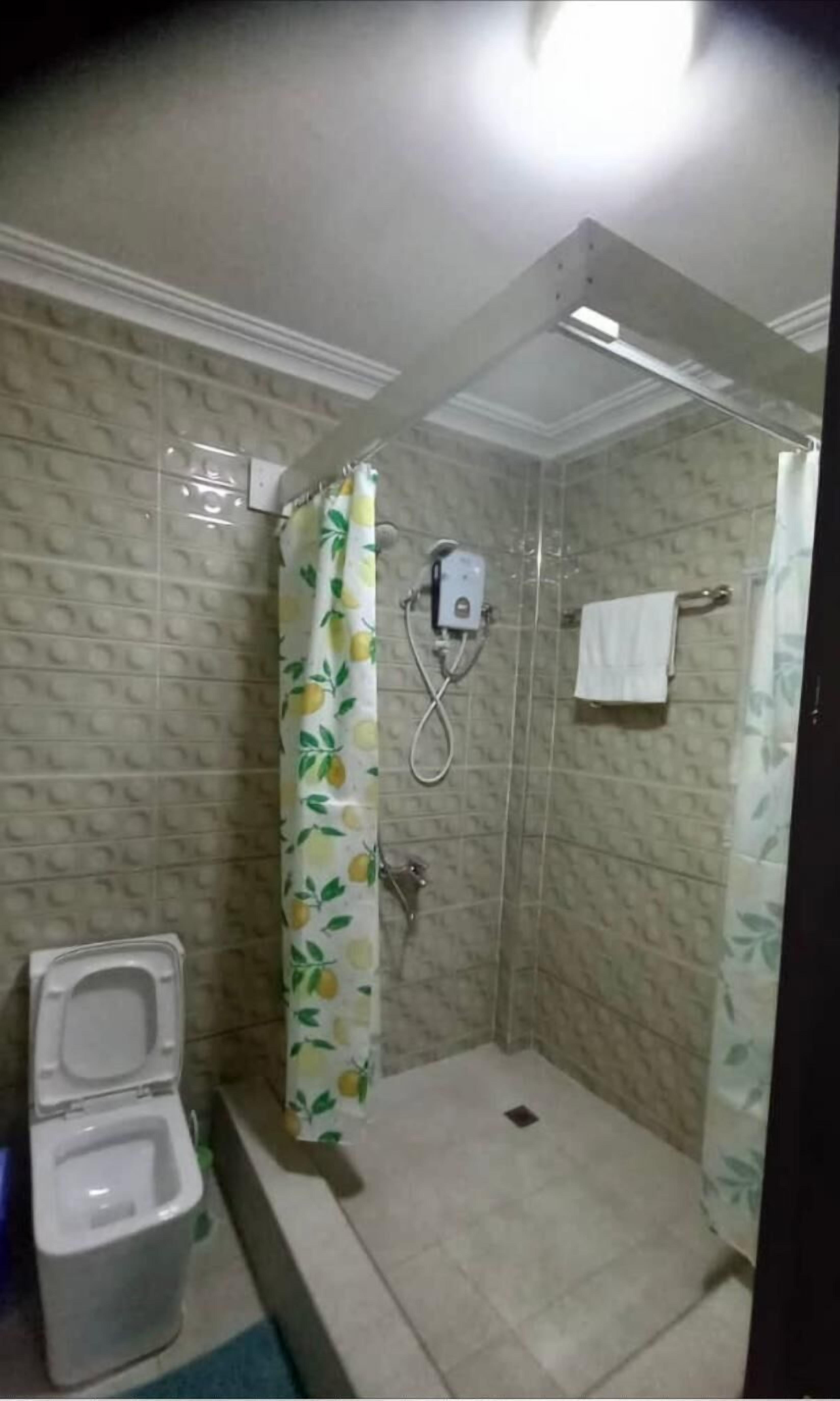 Un bagno con doccia, WC e porta asciugamani.