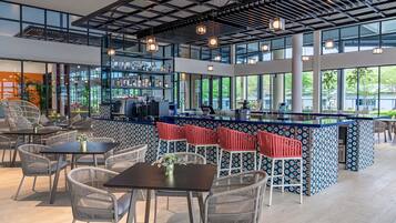 Un moderno bar con asientos, una barra y ventanas amplias.