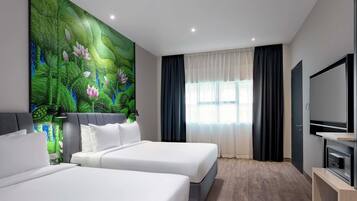 A hotel room with two beds, a large wall mural, a TV, and a window with curtains.