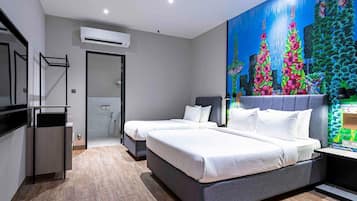 A modern hotel room with two beds, a shower, and a vibrant floral mural on the wall.