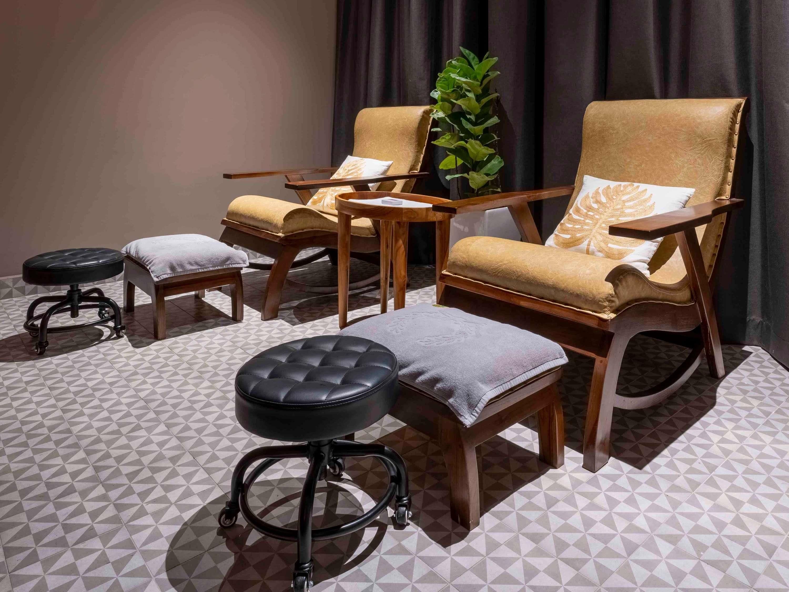 A seating area with a sofa, armchairs, a coffee table, and a small stool.