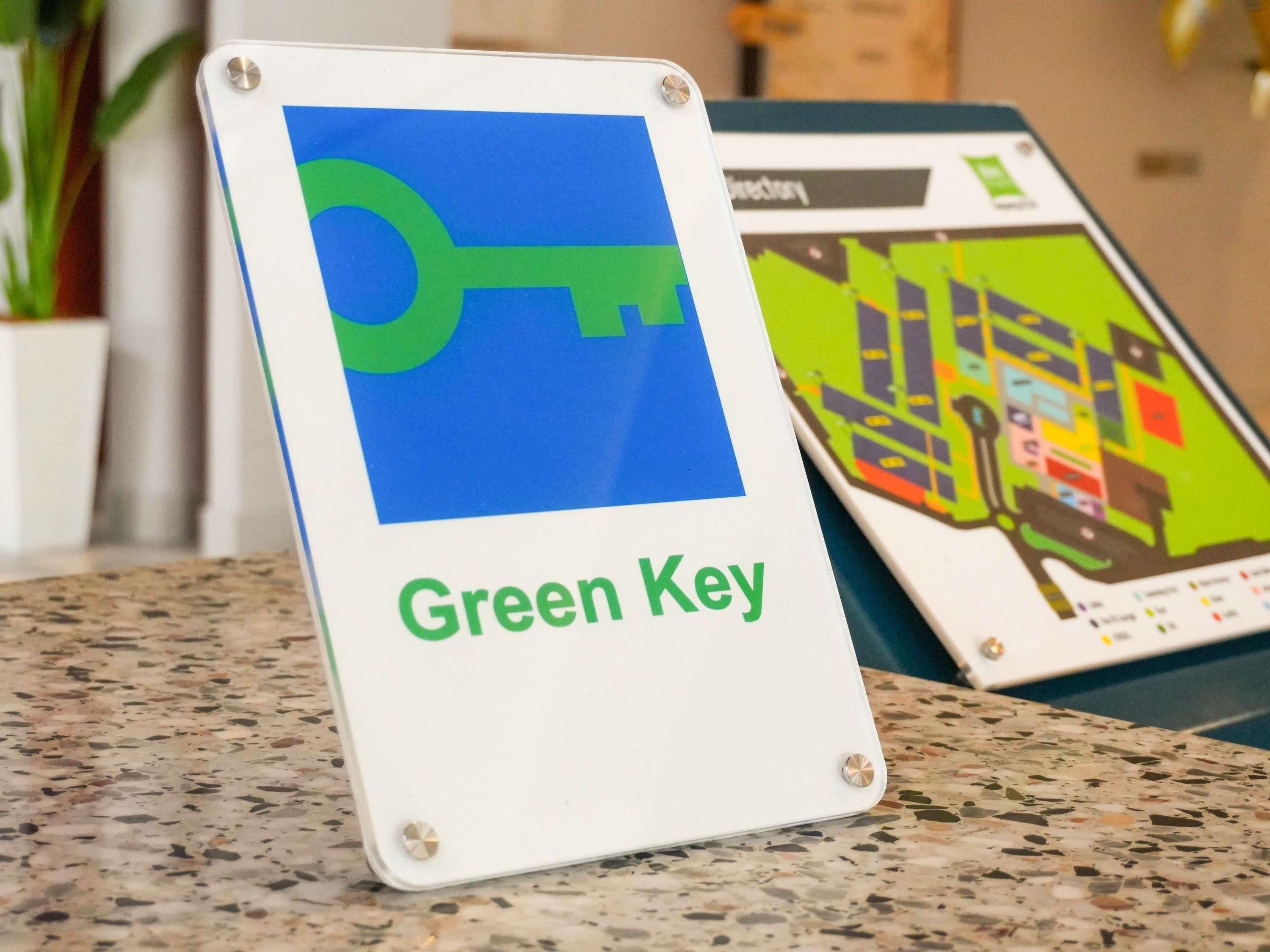 A sign with a key symbol and the text 'Green Key' on a white background.