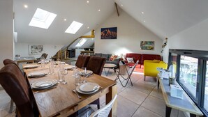A dining area with a wooden table set for six, a red sofa, and a yellow armchair. - Lac et montagne, charmant appartement idéalement placé! (Sévrier)