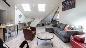 A spacious living area with a dining table, sofas, and a staircase leading to an upper level. - Lac et montagne, charmant appartement idéalement placé! (Sévrier)