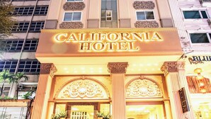 El exterior del California Hotel, con una entrada destacada, varios pisos y un cielo despejado.