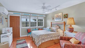 A bedroom with a bed, a chair, a sofa, a lamp, and a window. - White Buffalo Room With a View I Stargazing, Romantic (Wimberley)