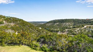 A mountainous landscape with scattered buildings and greenery. - White Buffalo Room With a View I Stargazing, Romantic (Wimberley)