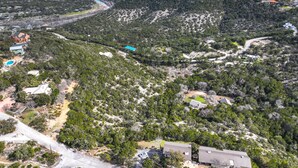 An aerial view of a residential area with scattered houses, a winding road, and a river. - White Buffalo Room With a View I Stargazing, Romantic (Wimberley)