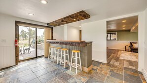 Una cocina con barra, baldosas de piedra y vistas al exterior.