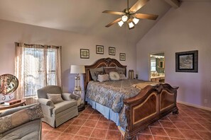 A bedroom with a large bed, a chair, a desk, and a ceiling fan. - Secluded Home - Canyon Lake View Near Boat Launch! (Canyon Lake)