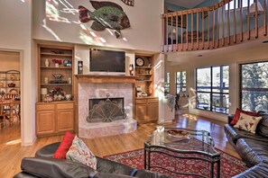 A spacious living room with a fireplace, a television, and a dining area with wooden furniture. - Secluded Home - Canyon Lake View Near Boat Launch! (Canyon Lake)