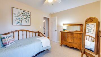 A bedroom with a bed, dresser, and a mirror.