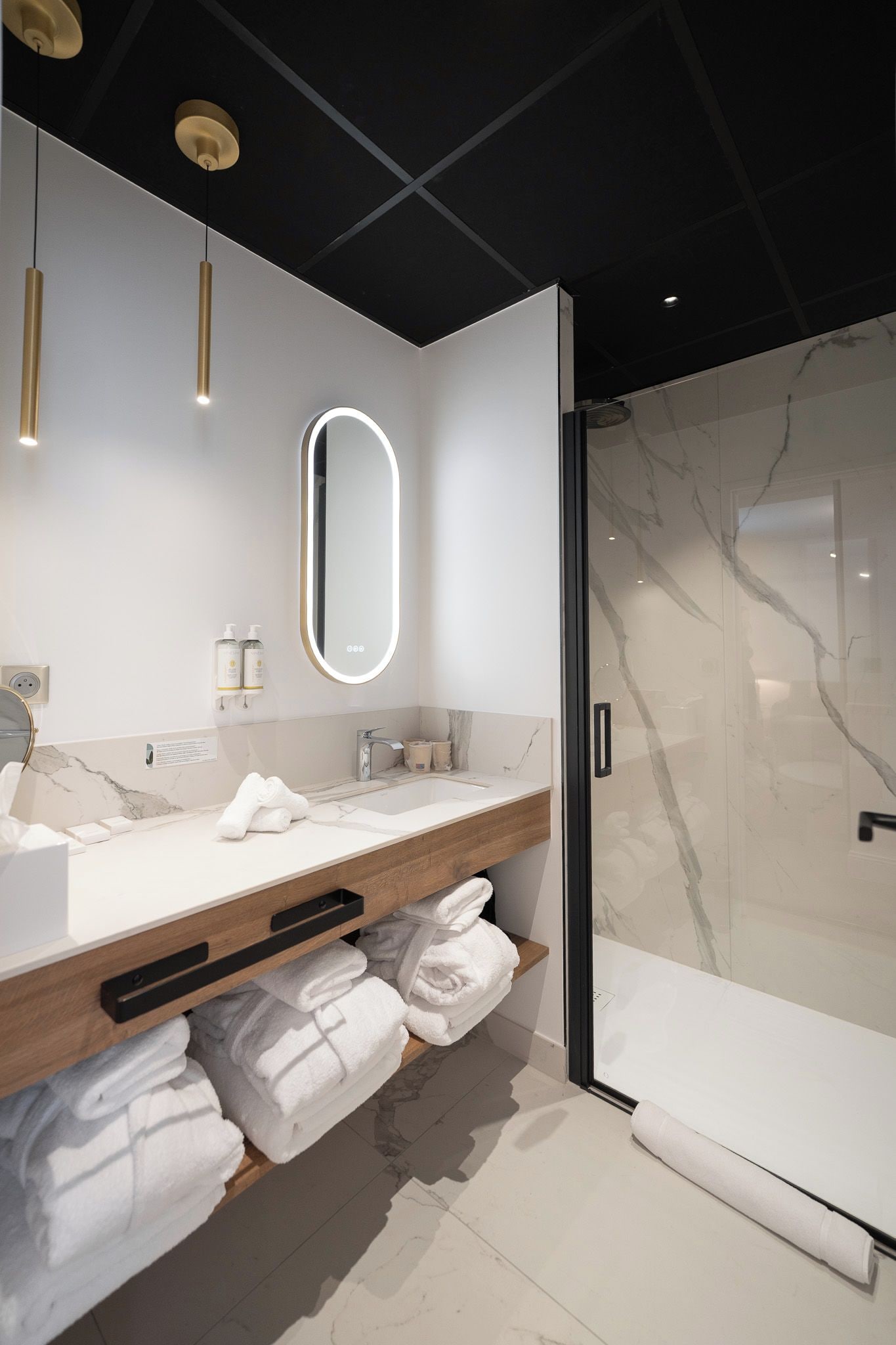 Un baño moderno con tocador doble, un espejo grande y cabina de ducha con paredes de vidrio.