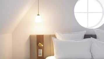 Une chambre à coucher avec un lit, une table de chevet, une lampe et une fenêtre.
