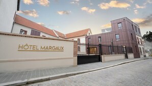 A hotel entrance with a sign reading "Hôtel Margaux" and a gated driveway. - Hôtel Margaux  (Epernay)