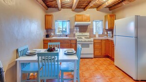 A kitchen with wooden cabinets, a white stove, and a refrigerator. - Quiet Mora Hideaway: 35 Mi to Angel Fire Resort! (Mora)