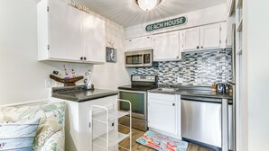 A compact kitchen with white cabinets, stainless steel appliances, and a tiled backsplash. - Hilton Head Island Condo w/ Coligny Beach Access! (Hilton Head Island)