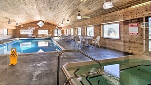 An indoor swimming pool with wooden walls and ceiling, surrounded by chairs and tables. - Nisswa Townhome w/ Boat Slip + Gull Lake Access! (Nisswa)