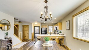 A spacious kitchen with wooden flooring, a central island, and a chandelier. - Nisswa Townhome w/ Boat Slip + Gull Lake Access! (Nisswa)
