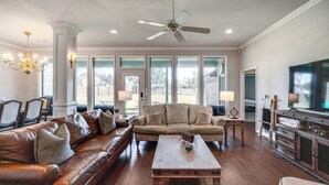 A spacious living room with a leather sofa, a wooden coffee table, and a television. - ~ 3 Mi to Dtwn: Aubrey Vacation Rental w/ Patio! (Aubrey)