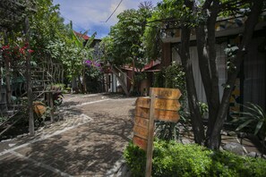 A cobblestone street with a wooden signpost indicating directions to various locations.