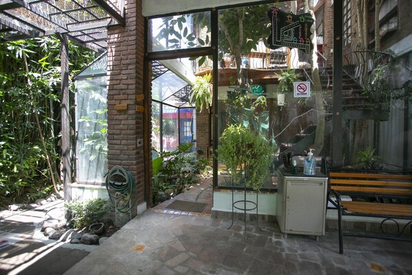 An indoor garden with a glass enclosure, a bench, and a small cabinet.