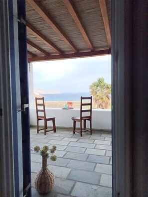 Step outside to a tranquil outdoor space with a scenic view of the sea and distant hills.