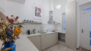 Una cocina moderna con horno empotrado, campana extractora de acero inoxidable y ventana sobre el fregadero.