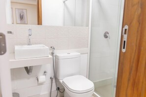 A bathroom with a toilet, a sink, and a shower area. - Augusta Hotel by Samba (Joao Neiva)