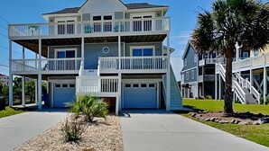 A multi-story residential building with balconies, a garage, and a well-maintained lawn. - The Salty Seahorse | Across from Beach + Views! (North Topsail Beach)
