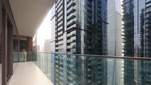 Un bâtiment moderne doté d’une façade en verre et d’un balcon avec une rambarde en métal.