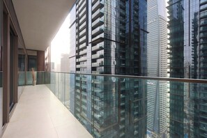 A modern building with reflective glass windows and a balcony with a metal railing.