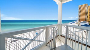 Een balkon met uitzicht op een strand en de oceaan.