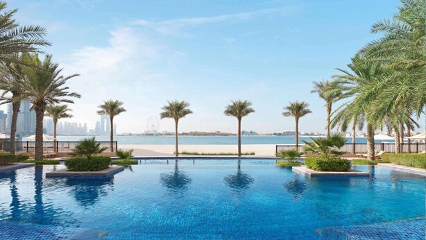 A swimming pool with a view of the beach and city skyline. - Seaside Studio in PalmJumeirah,Beach Access (Dubai)