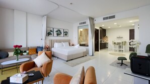 A modern hotel room with a bed, a sofa, a dining area, and a kitchen. - Seaside Studio in PalmJumeirah,Beach Access (Dubai)