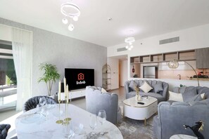 Relax in this stylish living room with a large flat-screen TV, comfortable sofa, and dining area.