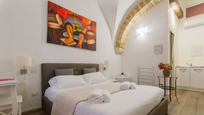 Een moderne slaapkamer met een groot bed, een bureau en een schilderij aan de muur.