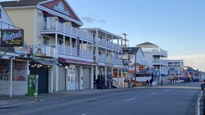 Una calle costera con edificios, incluyendo un restaurante de mariscos y un motel.