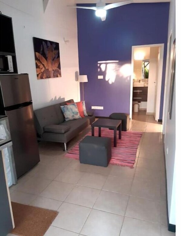 Cozy living space with a sofa, coffee table, and flat-screen TV.