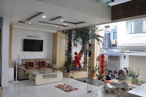 A modern living room with a sofa, coffee table, and a flat-screen TV. - Adventure Hotel (Ho Chi Minh City)