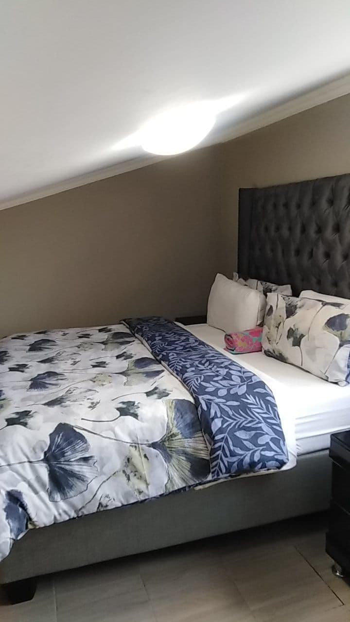A bedroom with a bed, a headboard, and a nightstand.