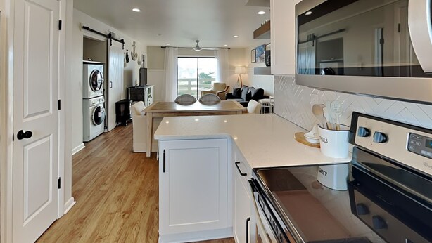 A modern kitchen with white cabinetry, a built-in oven, and a large island. - Lighthouse Point 7C | Easy Access to Pool & Beach! (Tybee Island)