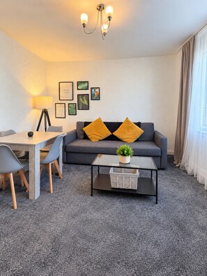 Un salon moderne avec un canapé, une table basse et un coin repas.