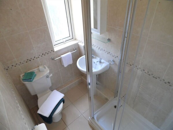 Ein kleines Badezimmer mit Toilette, Waschbecken und Duschkabine.
