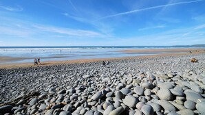 A pebbled beach with a clear sky and calm sea. - 2 Bed in Abbotsham (oc-g28822) (Abbotsham)