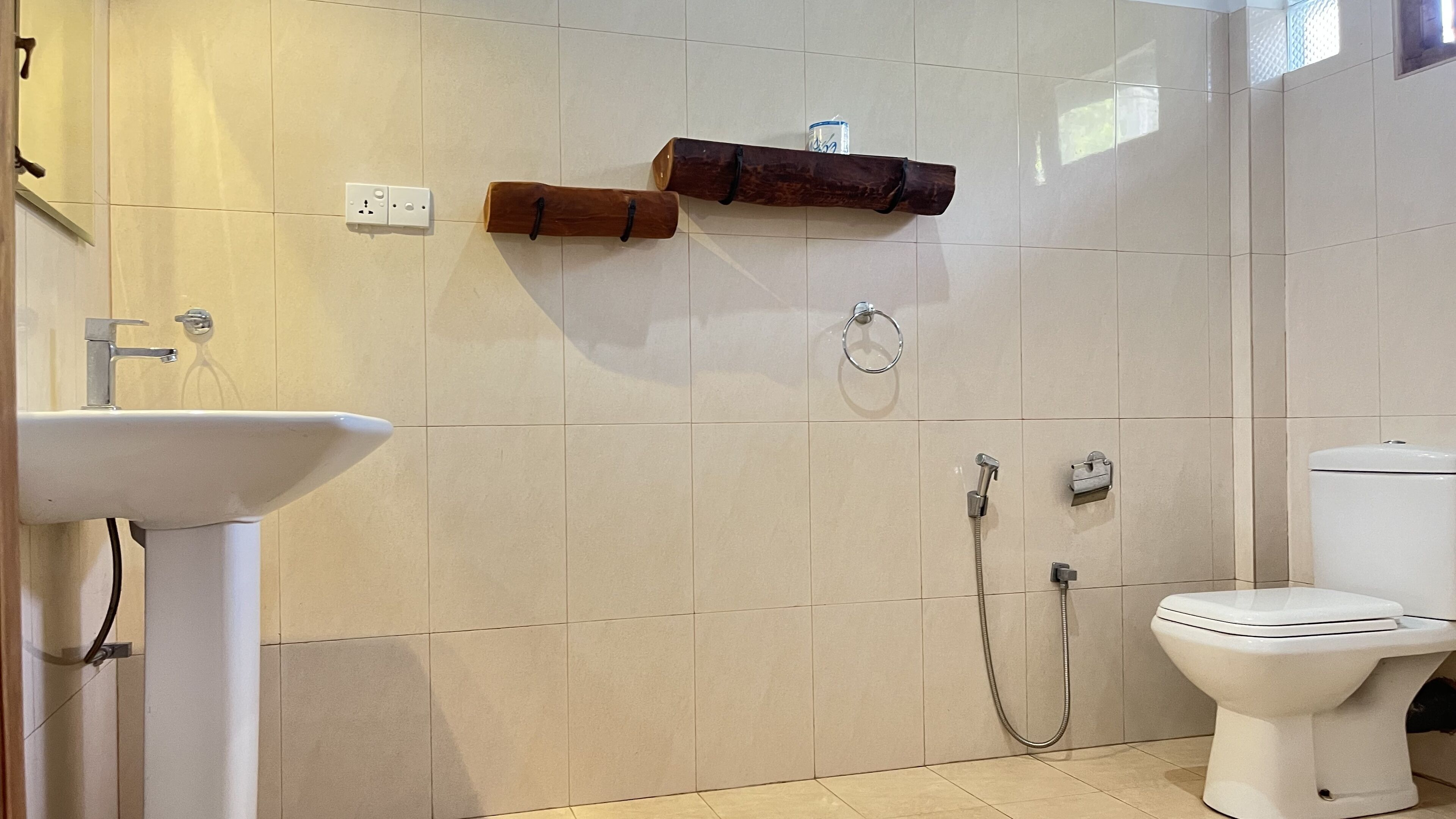 Een badkamer met wastafel, toilet en douche.