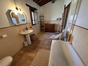 Un baño con lavamanos, inodoro y bañera.