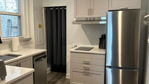 A modern kitchen with white cabinetry, stainless steel appliances, and a wooden floor. - Best Location in AC! Near Boardwalk, Casino Action (Atlantic City)